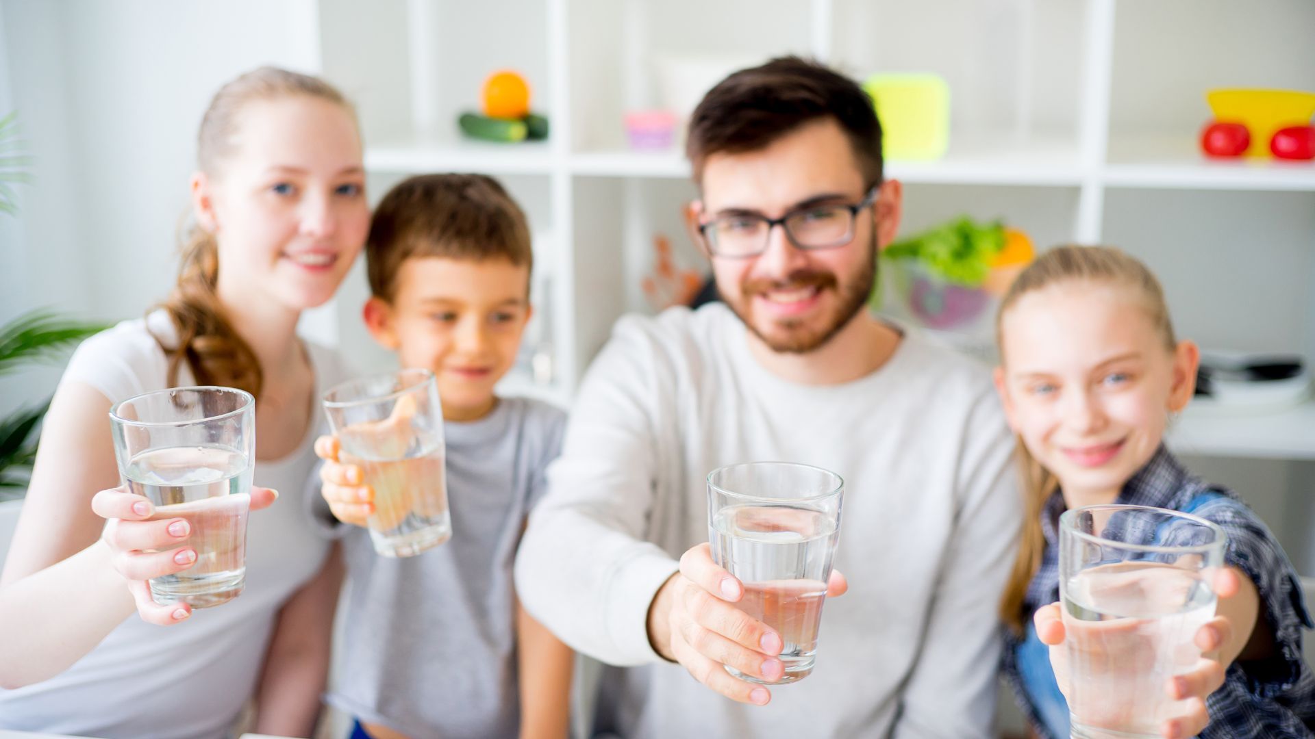Rodzina trzymająca szklankę z różnymi rodzajami wód.