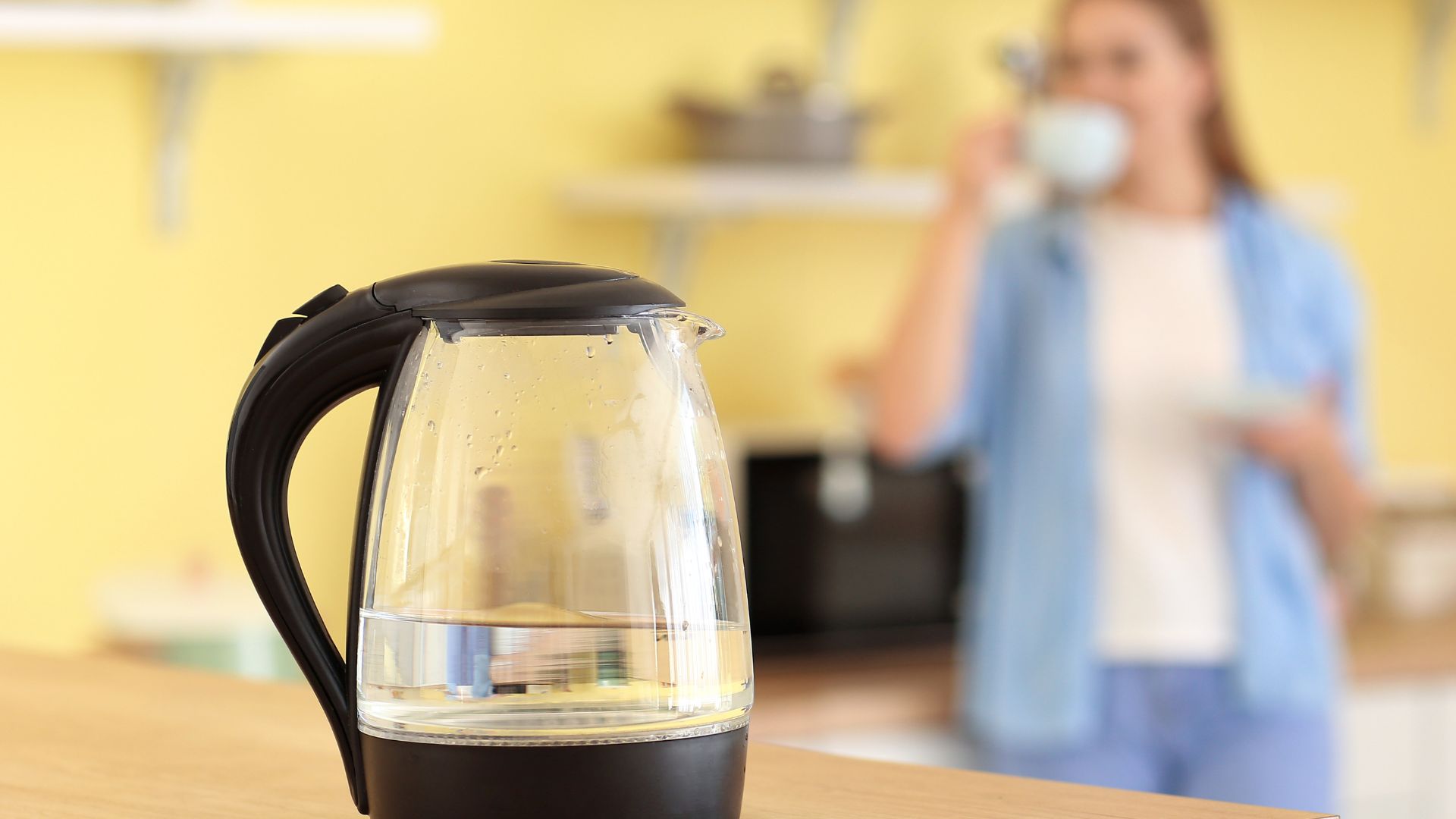 Czajnik z przegotowaną wodą na drewnianym stole  Czajnik z przegotowaną wodą na drewnianym stole