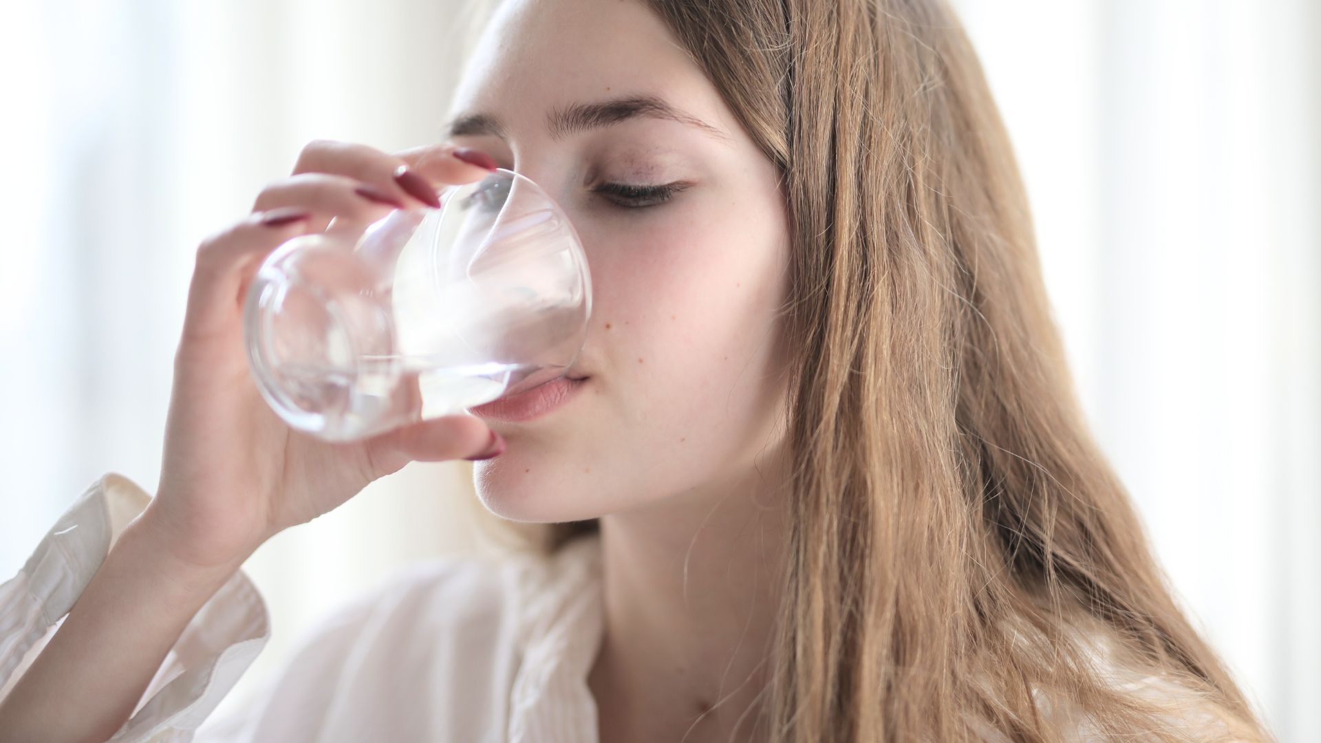 Kobieta pijąca wodę RO po procesie oczyszczenia z systemu RO